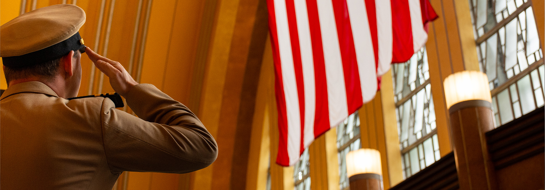 photo of veteran saluting the large flag in the CMC Rotunda